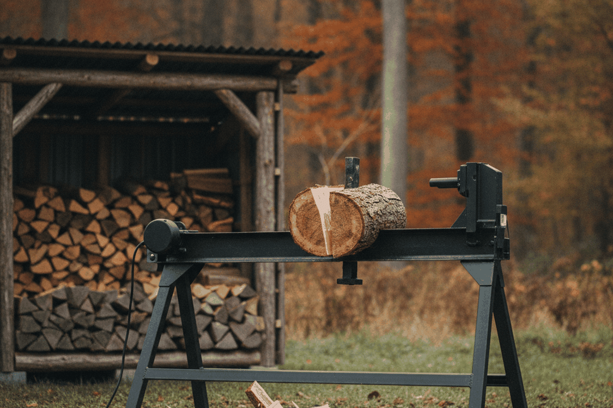 electric log splitter on a steel stand with a round on the beam mid split