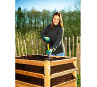 Gardener working a wooden raised bed with the Spear Head Spade SHMini