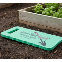 Spear Head Spade garden kneeler on dark soil beside a raised bed