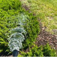 Spraying a garden bed with a hose-end sprayer