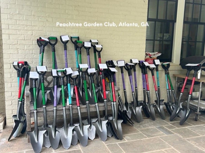 Rows of Spear Head Spades in many colors lined up against a wall for a garden club planting day